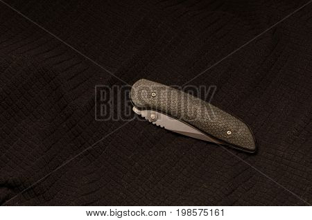 Black Knife Folded On A Black Background. Front Side