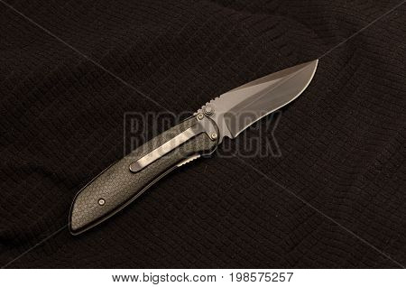 Black Knife On A Black Background. Back View. Black On Black.