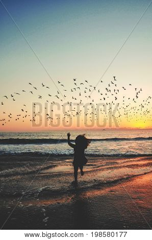 Girl trying to catch a bird, she wants to be free