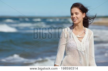 Young woman walking on white sand to beautiful beach, Baltic Sea, Poland