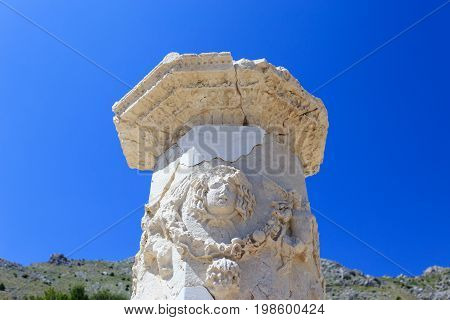 Carved marble column in agora of ancient city of Sagalassos with agora on background