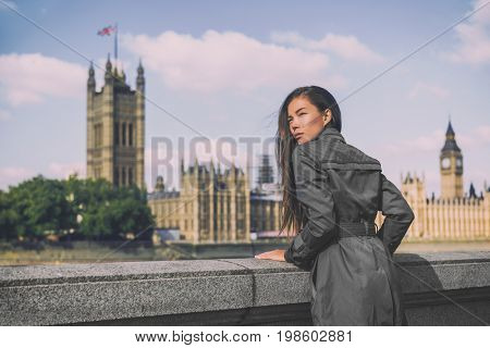 London trench coat business woman at Westminster. Fashion businesswoman in grey raincoat. Asian beauty model outdoor.