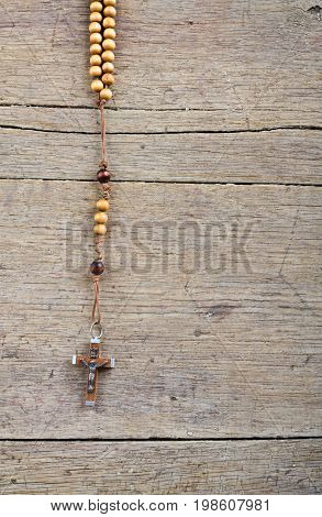 Rosary beads on the old wooden table