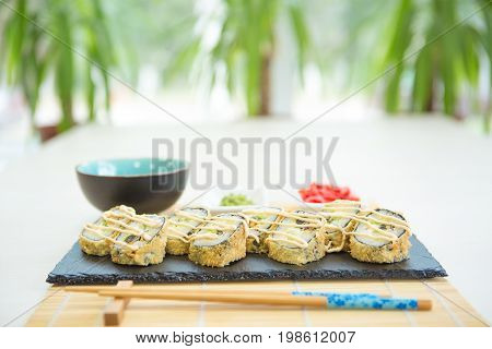 Sushi Rolls On Black Slate Surface. Japanese Food. Hot Fried Sushi Roll