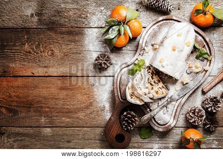 Christmas stollen, traditional German, European festive dessert cut into pieces on wooden background. Top view, Black background