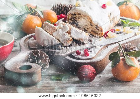 Christmas stollen, traditional German, European festive dessert cut into pieces on wooden background.