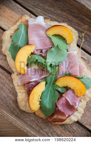 Home made tarte flambee with ham and arugula