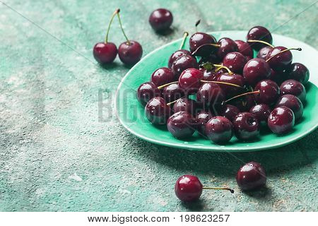 Fresh cherry on plate on blue background. ripe cherries. sweet berries.