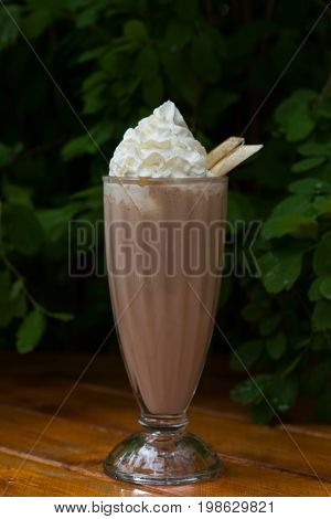 banana smoothie in a glass On a wooden background. banana cocktail.