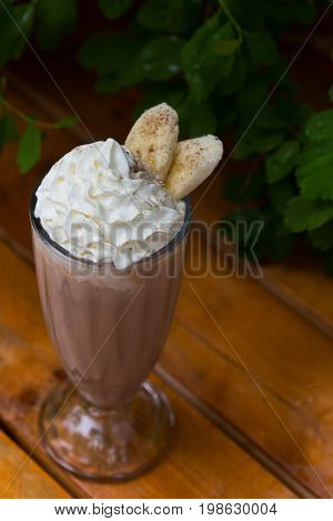 banana smoothie in a glass On a wooden background. banana cocktail. close up.