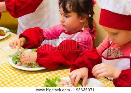 Alchevsk, Ukraine - July 30, 2017: School Cooks For Children. Learn To Cook Pasta With Sausages
