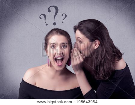 A teenager girl looking confused with drawn question marks above the head, while a girlfriend whispers something in her ear concept.