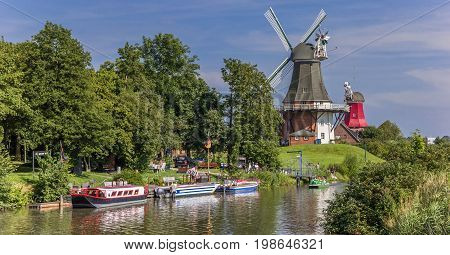 GREETSIEL, GERMANY - JULY 18, 2017: Windmills along the river in Greetsiel, Germany