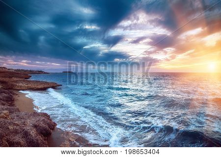 Beautiful colorful sunset at the sea with dramatic clouds and sun shining. Beauty world natural outdoors travel background