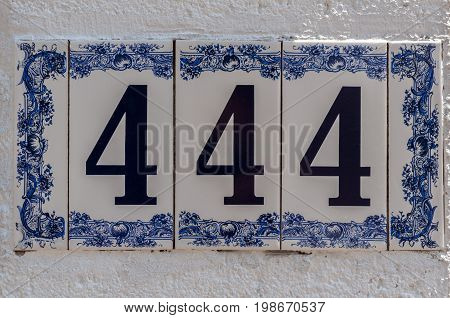 Number 444. Street number. Address. Plate on a wall
