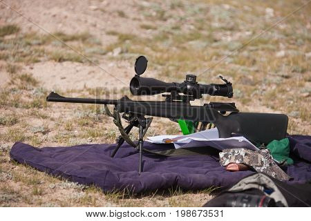 A hunting rifle with optical sight and bipod support while zeroing on the hunt in the mountains of Tien Shan Kyrgyzstan