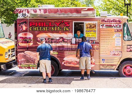 Washington DC USA - July 3 2017: Food trucks on street by National Mall with Philly's Cheese steak storefront on Independence Avenue