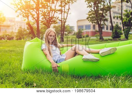 Young Woman Resting On An Air Sofa In The Park.