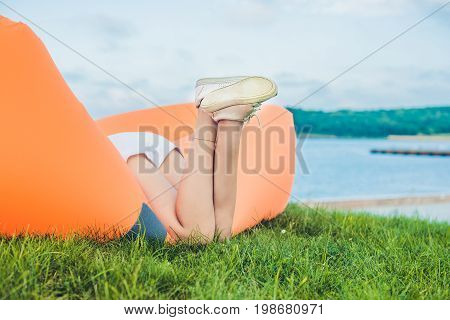Young Woman Resting On An Air Sofa In The Park.