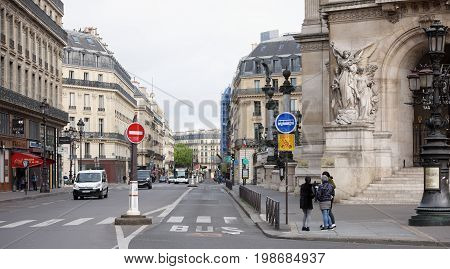 ParisFrance- April 30 2017: View on Street Auber with the Palais Garnier opera. On the street pedestriansgoing transport
