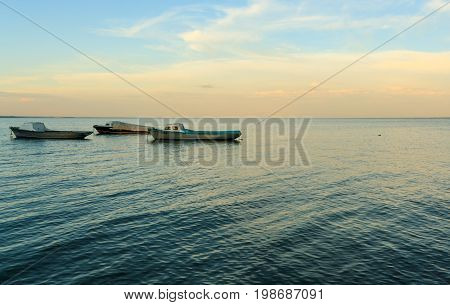 boats in sea at sunrise, a calm sea