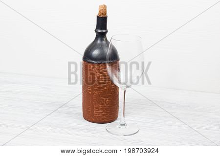 Black bottle of wine and wneglass on the background of the canvas