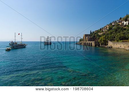 ALANYA TURKEY - JULY 04 2015: Shipyard (Tersane) and the ruins of a medieval fortress (Alanya Castle) on the mountainside.