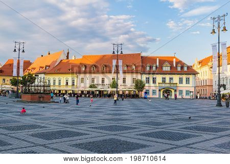 SIBIU ROMANIA - JUNE 19 2017: Large main square Huet with ancient houses and tourists on the street in the summer.