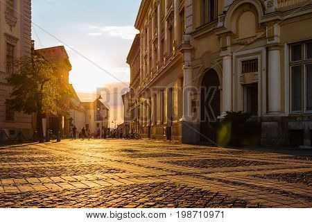 Large main square Huet with City Hall and people on the street at golden sun light ancient medieval city Sibiu Romania.