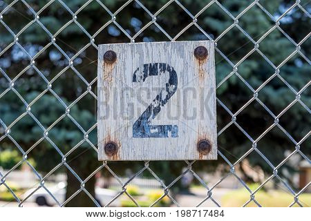 Sign of the number two on a fence in an urban park
