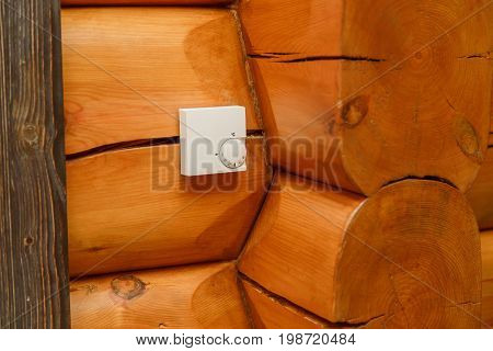 Room temperature controller for heating and cooling on a wall in a wooden house