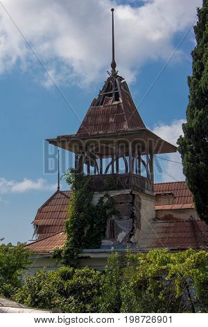 Tower of old beautifull abandoned mansion overgrown by plants and trees. Sukhum, Abkhazia