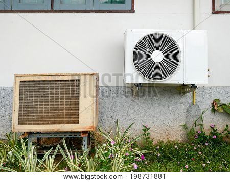 new air conditioner condenser and old air conditioner condenser unit standing outdoors on wall