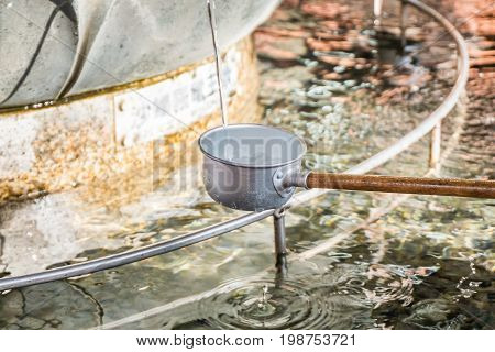 hand pouring water to bowl from purification fountain at senso-ji temple in asakusajapan