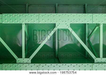 close up of green metal bridge structure for support trains