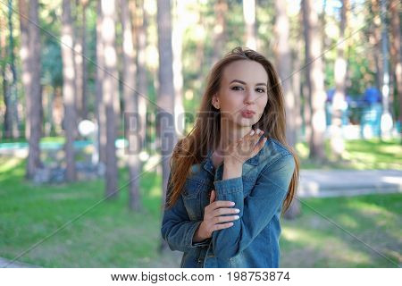 sexy beautiful woman showing air kiss in the park