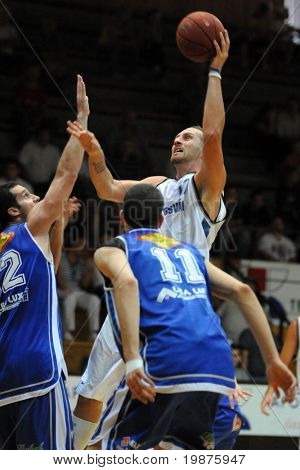 KAPOSVAR, Ungarn - SEPTEMBER 4: Gergely David (i hvidt) i aktion på en venlig basketballkamp Ka