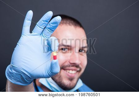 Selective Focus Of Doctor Wearing Scrubs Holding One Pill