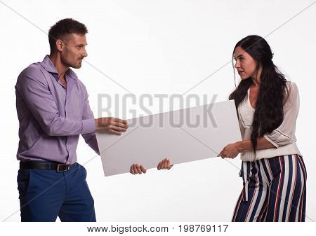 Young jocular woman portrait of a confident businesswoman showing presentation, pointing placard gray background. Ideal for banners, registration forms, presentation, landings, presenting concept.