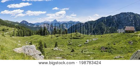 View from Auernig Alm with old huts on Nassfeld in Carnic Alps to Julian Alps in Italy