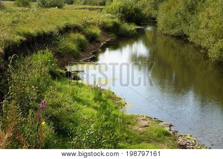 River coast with green grass. Russian nature.