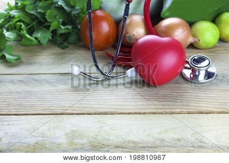 Healthy hearth concept vetgetable and fruit with herb leaf and ear doctor on wood background