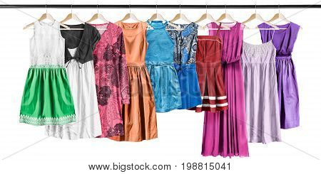 Group of dresses hanging on clothes racks on white background