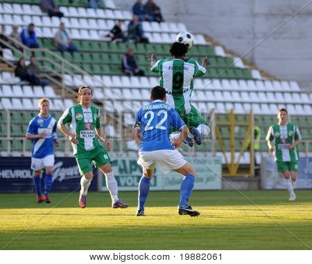 KAPOSVÁR, Hungria - 17 de abril: Egejuru (9) dirige a bola em um futebol Campeonato Nacional Húngaro
