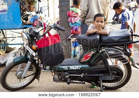 HOSPET, INDIA - FEBRUARY 20, 2013 - Cute indian boy on the motorbike