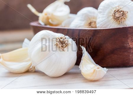 Garlic Cloves and Garlic Bulb in vintage wooden bowl. Garlic is a Thai herb and is a spice. Usually put in many kinds of food.