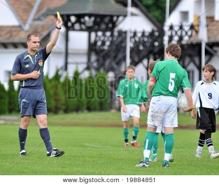 KAPOSVAR, HUNGARY - MAY 29: Laszlo Radak (referee) presents a yellow card at the Hungarian National Championship under 13 game between Kaposvari Rakoczi and Paks May 29, 2010 in Kaposvar, Hungary.