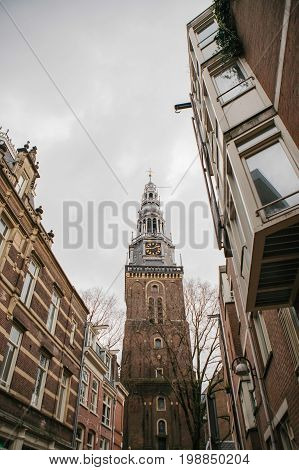 Image of Oudekerk Bell Tower with clock In Amsterdam, Netherlands.