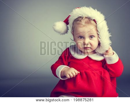 portrait of cute female caucasian child with santa claus clothes
