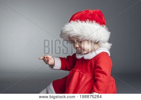 portrait of cute female caucasian child with santa claus clothes